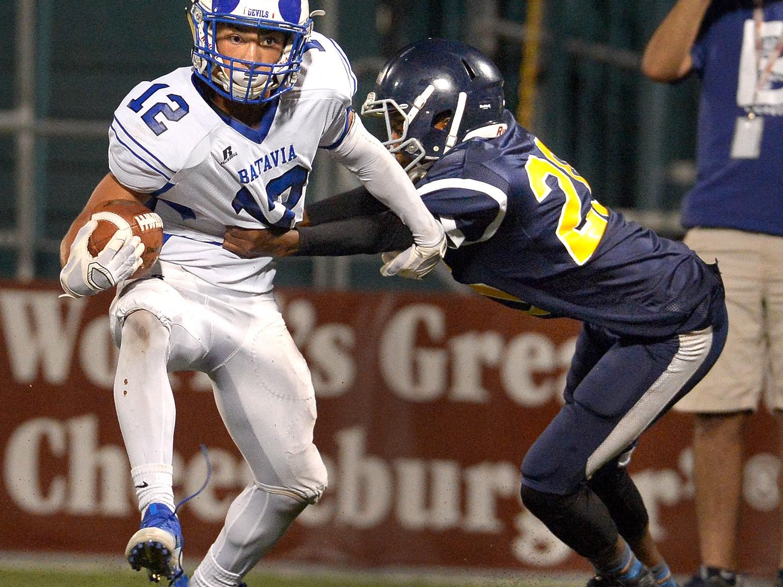 Batavia's Chandler Baker, left, breaks the grasp of University Prep's Cassisus Facen on his way to the Blue Devils' second touchdown at Rhinos Stadium on Friday.