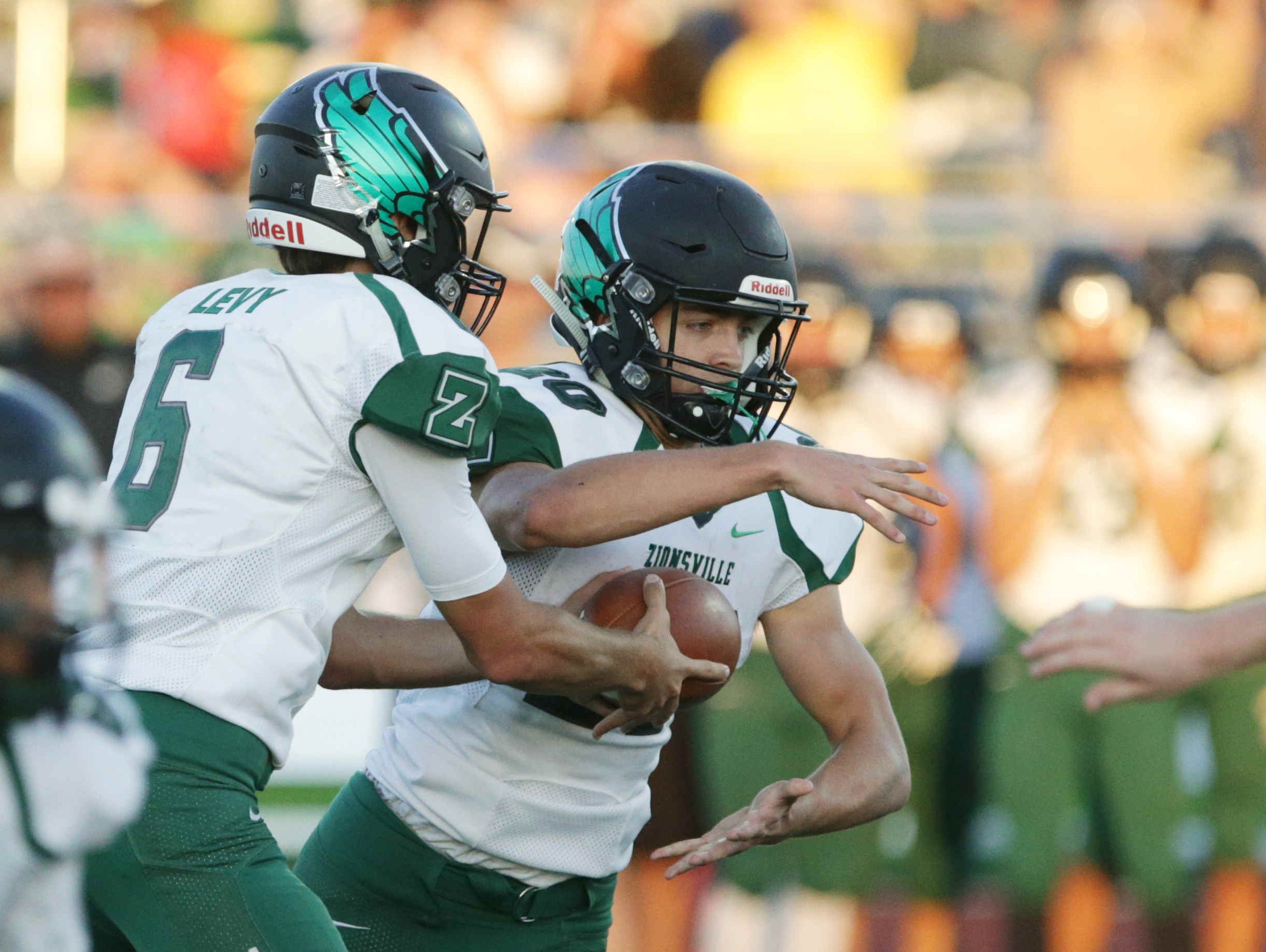Zionsville's QB, No. 6, Blake Levy fakes a hand off to No. 20, Brenden Mikesell, Friday September 2nd, 2016. Westfiled faced off against Zionsville at Westfields's Riverview Health Stadium.