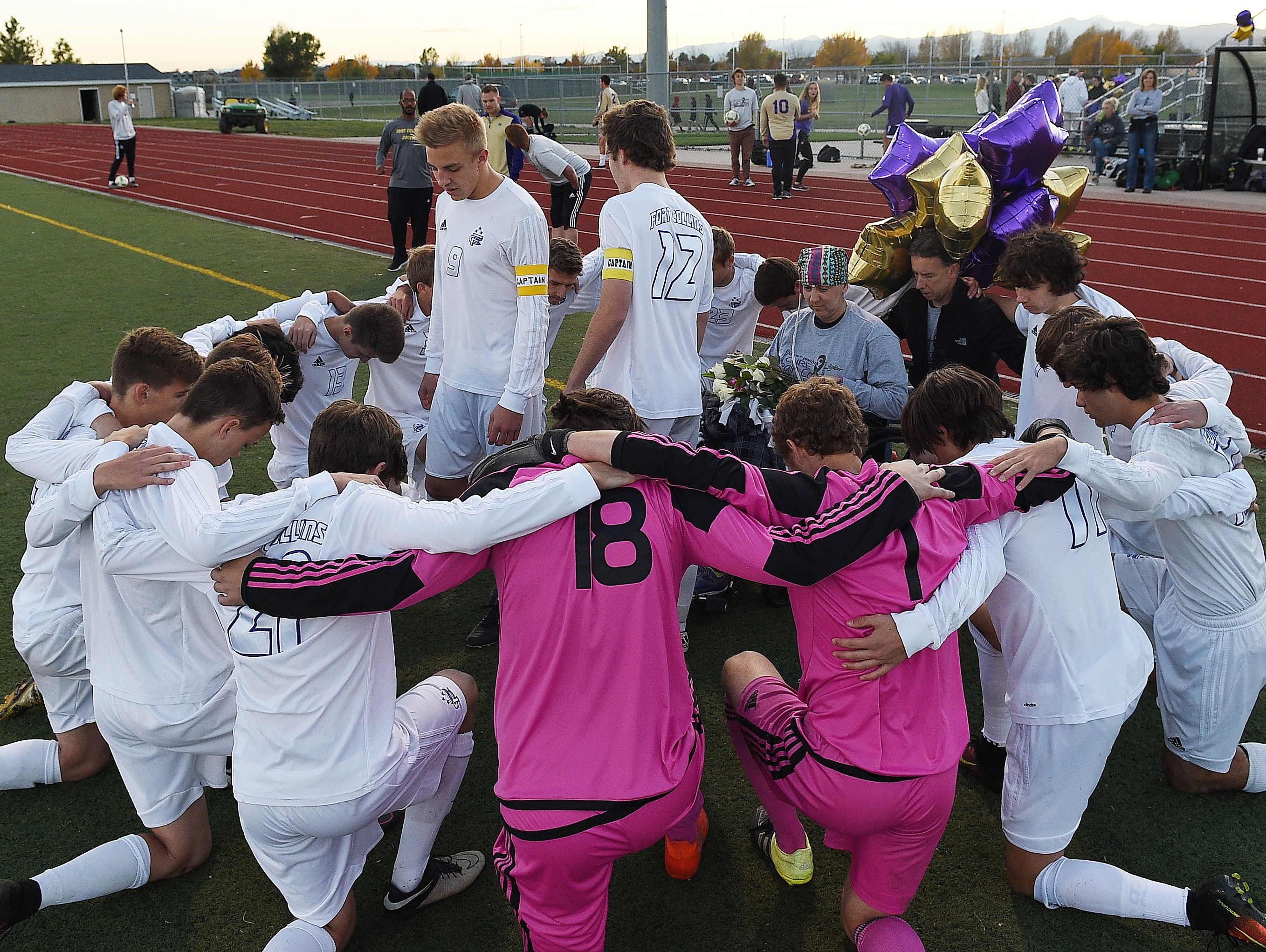 Team captains Derrick Eberling and Matthew Rhoads lead a prayer with honorary captain Heather Keaten before a Fort Collins High School soccer game on Thursday, October 20, 2016. Keaten has stage IV brain cancer and the team sold t-shirts and collected donations at the game to raise money for her care.