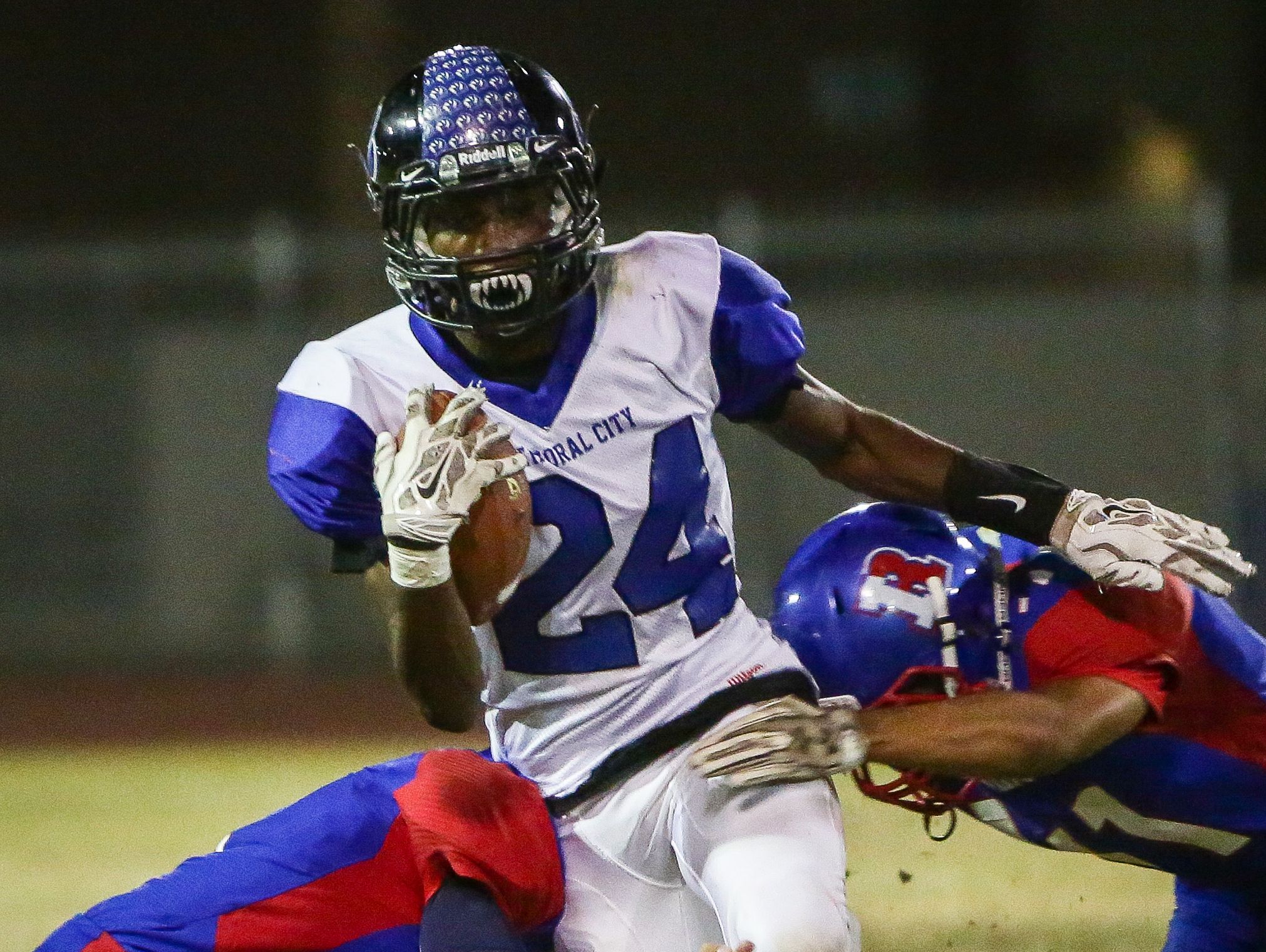 Cathedral City's James Green sneaks between two Indio defenders on Friday during the Lions' 34-7 victory.