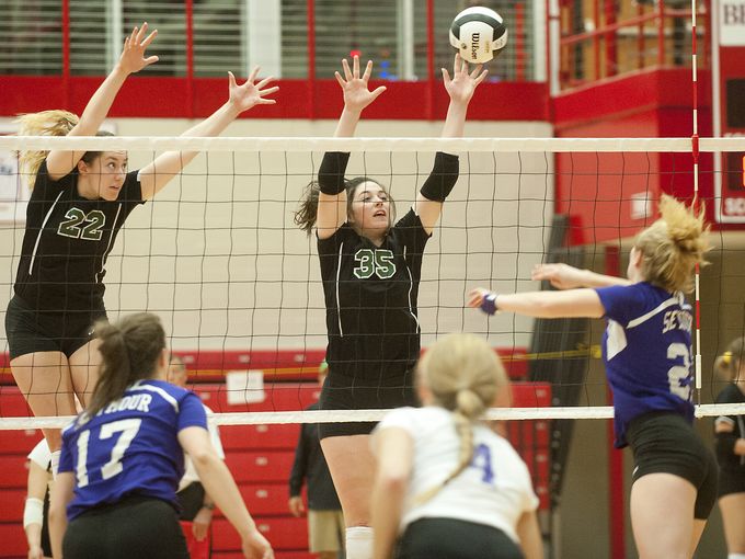 Floyd Central's Mia Swearingen and Claire Meyer look to block a Seymour kill Saturday night.