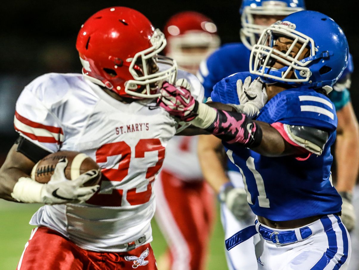 Orchard Lake St. Mary's Troy Marks catches the ball, before being tackeld by Novi Detroit Catholic Central's Chyle Johnson during the first half at Catholic Central in Novi on Oct. 9, 2015.
