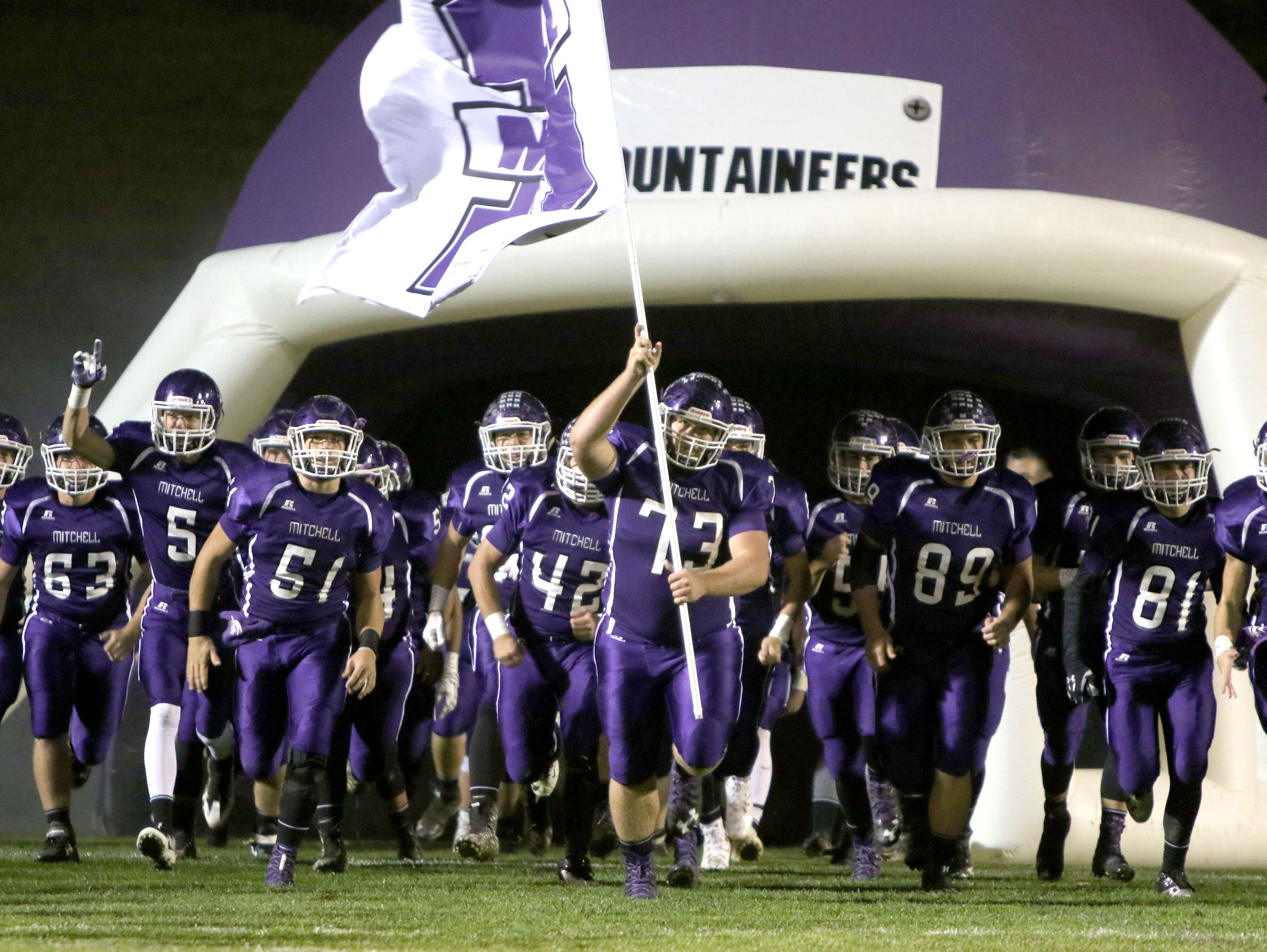 Mitchell football players take the field for last Friday's home game against Mountain Heritage.