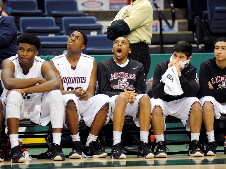 Aquinas players look on from the bench.