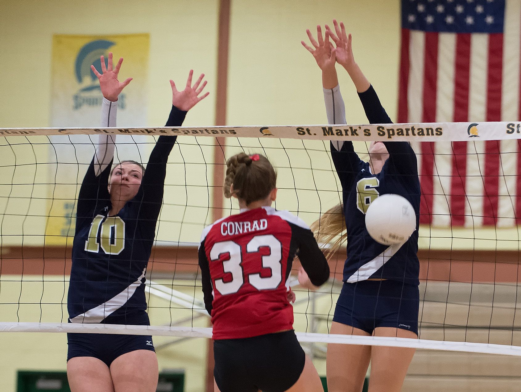 Delaware Military Academy's Natalie Lavelle (10) and Victoria Taylor (6) block a spike attempt by Conrad's Julie Kulesza (33) in the second round game of the DIAA State Volleyball Tournament.