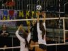 Plymouth Christian’s Grace Kellogg tips the ball over the net and Leland's Hanna Elwell for a point at Kellogg Arena.