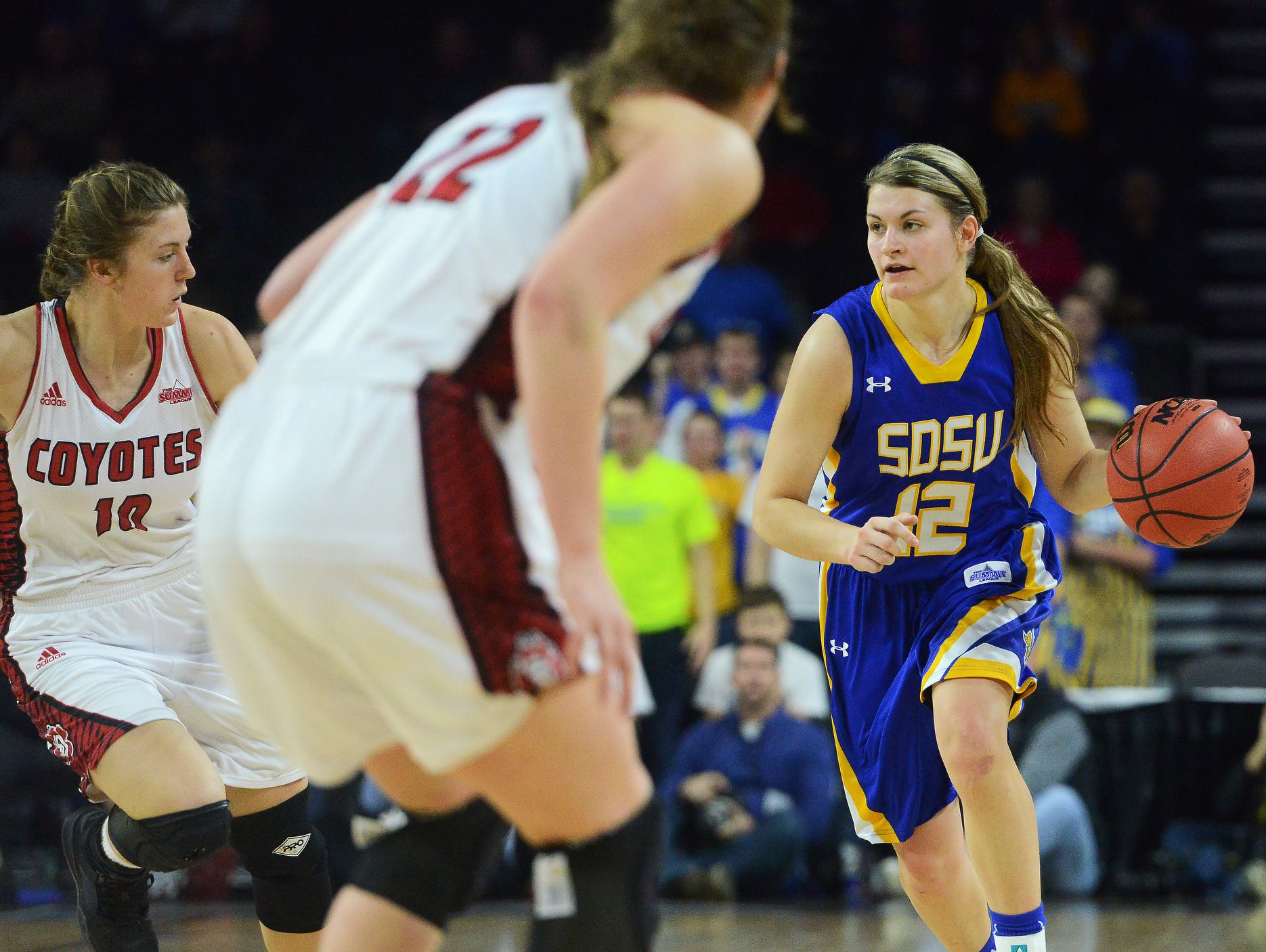 SDSU's Macy Miller (12) dribbles down the court alongside USD's Allison Arens (10) in the Summit League women's basketball championship Tuesday at the Denny Sanford Premier Center in Sioux Falls, S.D. March 8, 2016. SDSU beat USD 61-55.
