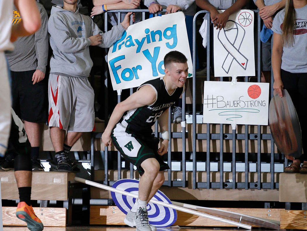 Williamston's Riley Lewis reacts after hitting a shot in front of the Lansing Catholic student fans, who wore gray and had signs with messages of support for Williamston coach Jason Bauer, Friday, March 11, 2016, at Fowlerville High School. Williamston won 70-60.