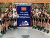 Members of Wilson Memorial's girls basketball team pose in front of the banner the school received for winning the VHSL's Claudia Dotson award for the 2015-16 school year.