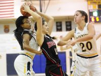 Port Huron's Alexis Cantu is swarmed by Port Huron Northern's Jenna Koppinger and Olivia Ramsey on Dec. 9, 2016.