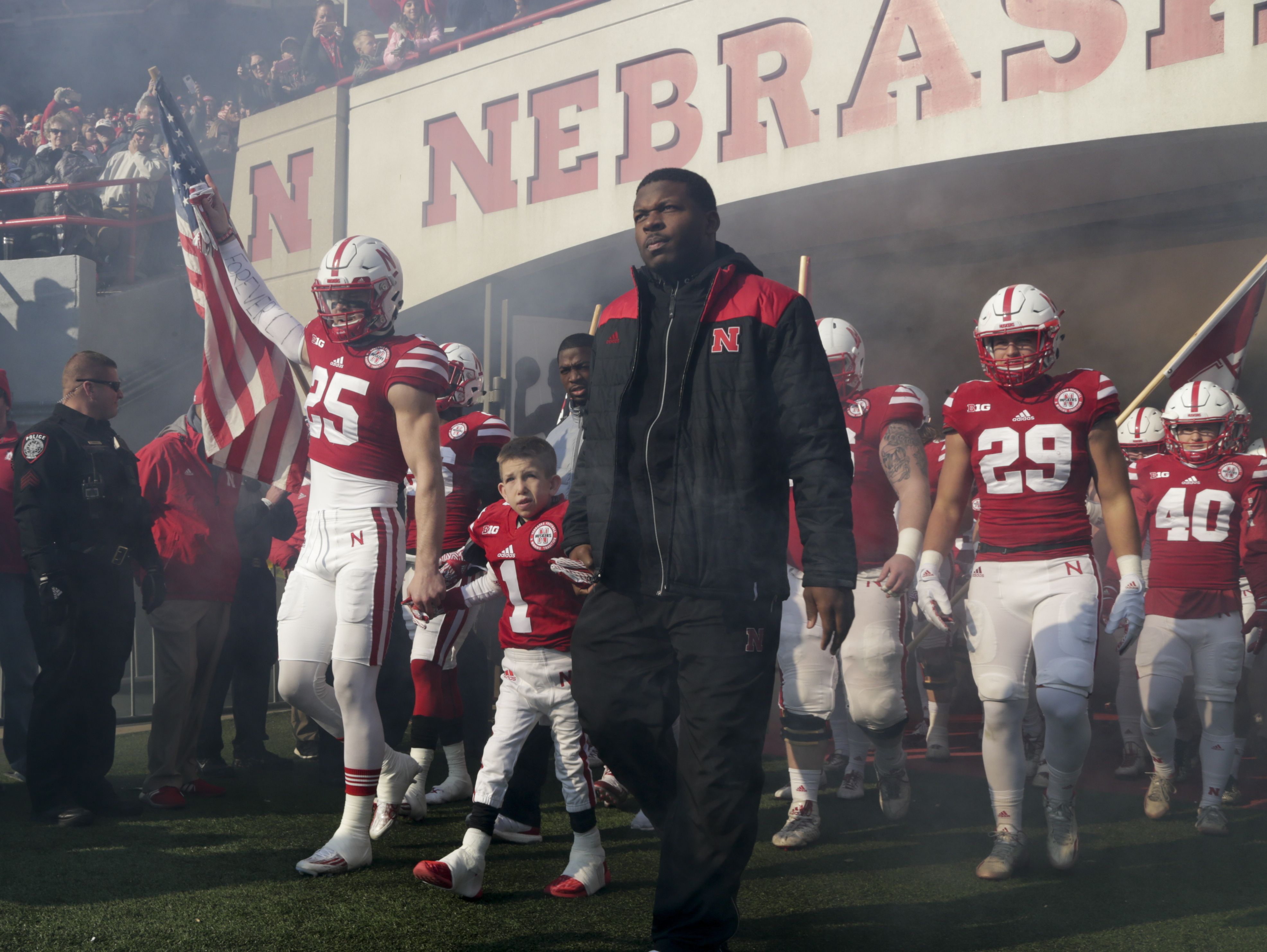 8 year-old Jack Johnson (1), who suffers from Menkes disease, leads the Nebraska team onto the field at Memorial Stadium between Nate Gerry (25) and quarterback Tommy Armstrong Jr., right.