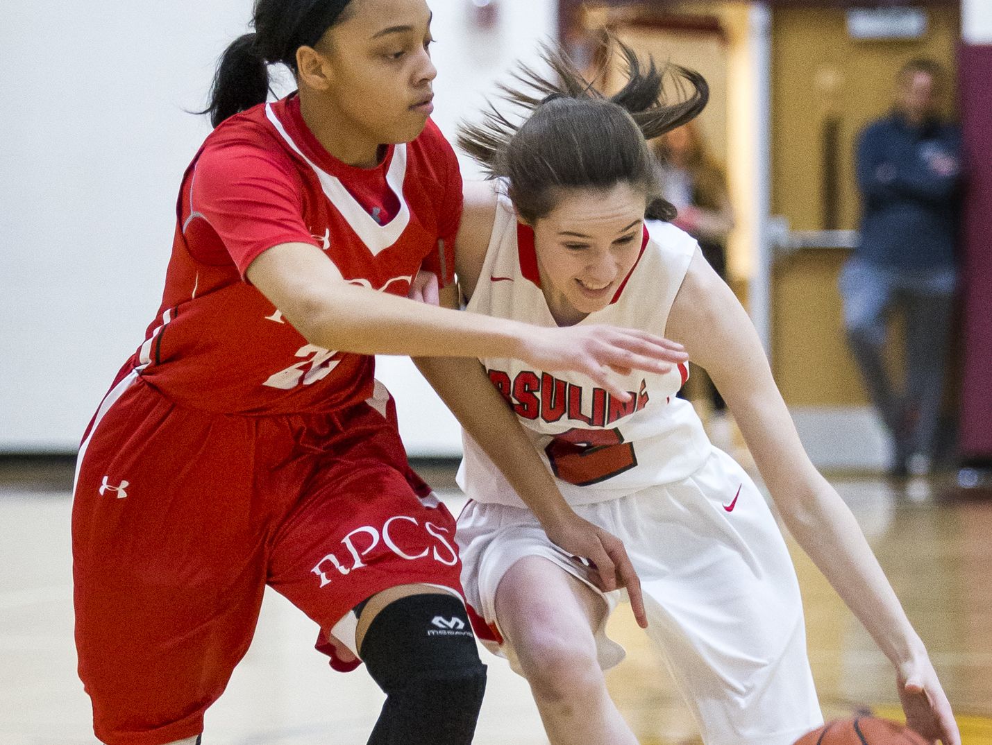 Ursuline's Maggie Connolly drives to the basket against Roland Park's Aniyah Carpenter in the first half of Ursuline Academy's 47-40 win over Roland Park Country School in the Diamond State Classic at St. Elizabeth High School in Wilmington on Friday evening.