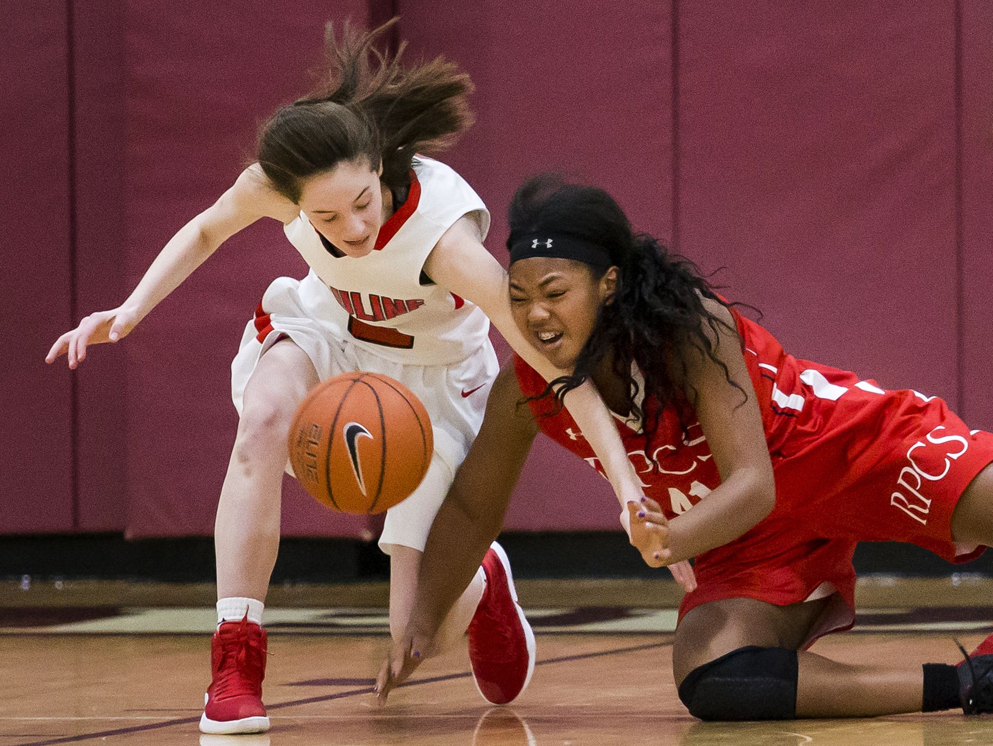 Ursuline's Maggie Connolly (left) fights for a loose ball with Roland Park's Christyn Robinson (right) in the first half of Ursuline Academy's 47-40 win over Roland Park Country School in the Diamond State Classic at St. Elizabeth High School in Wilmington on Friday evening.