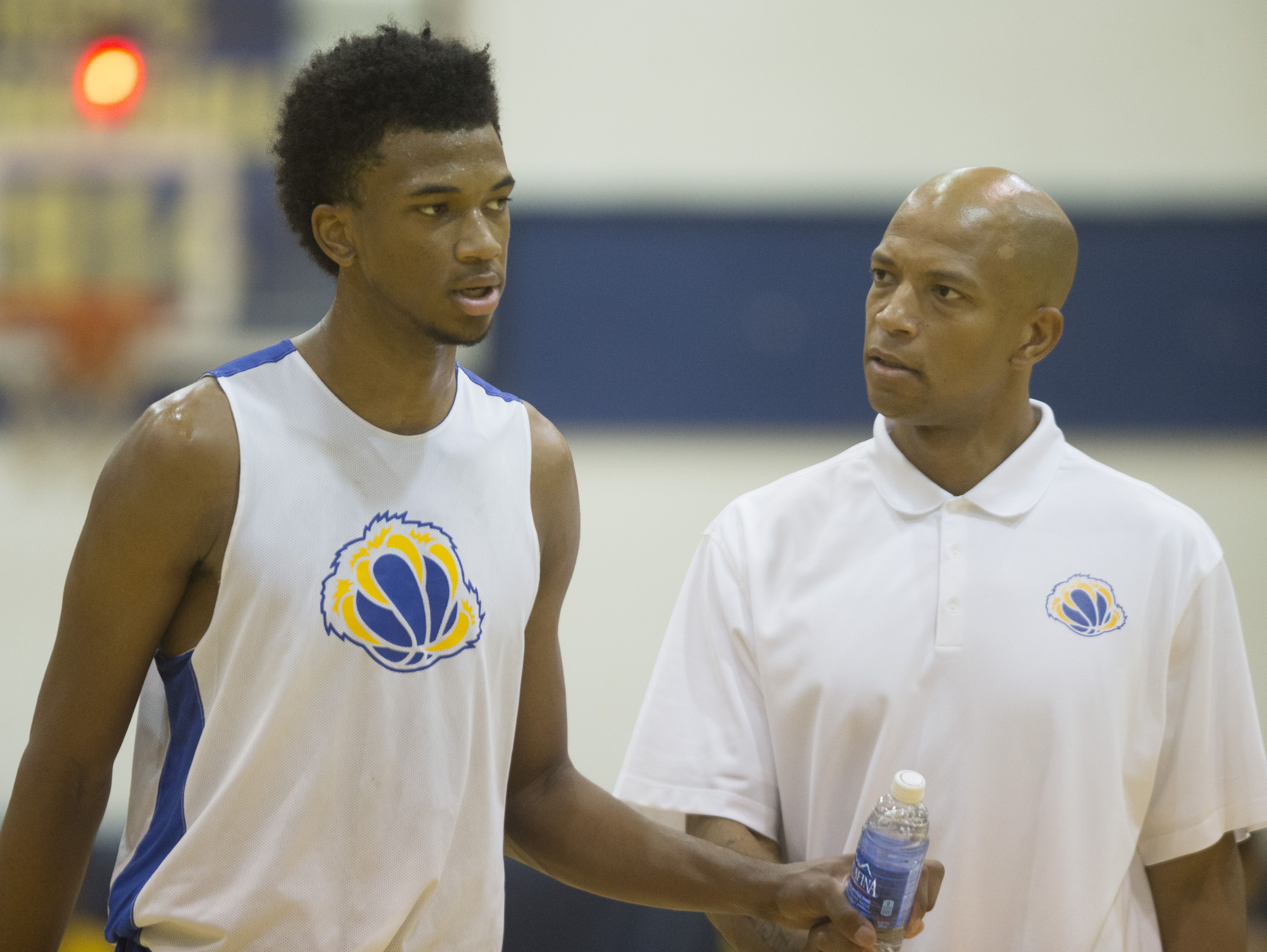 Assistant Coach Marvin Bagley Jr. (R) and his son Marvin Bagley III talk during an exhibition game against Phoenix Community College at Phoenix Community College in Phoenix, AZ on October 8, 2015.