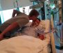 Taron Maronic receives a kiss from his brother while in the hospital following a football injury Family photo)