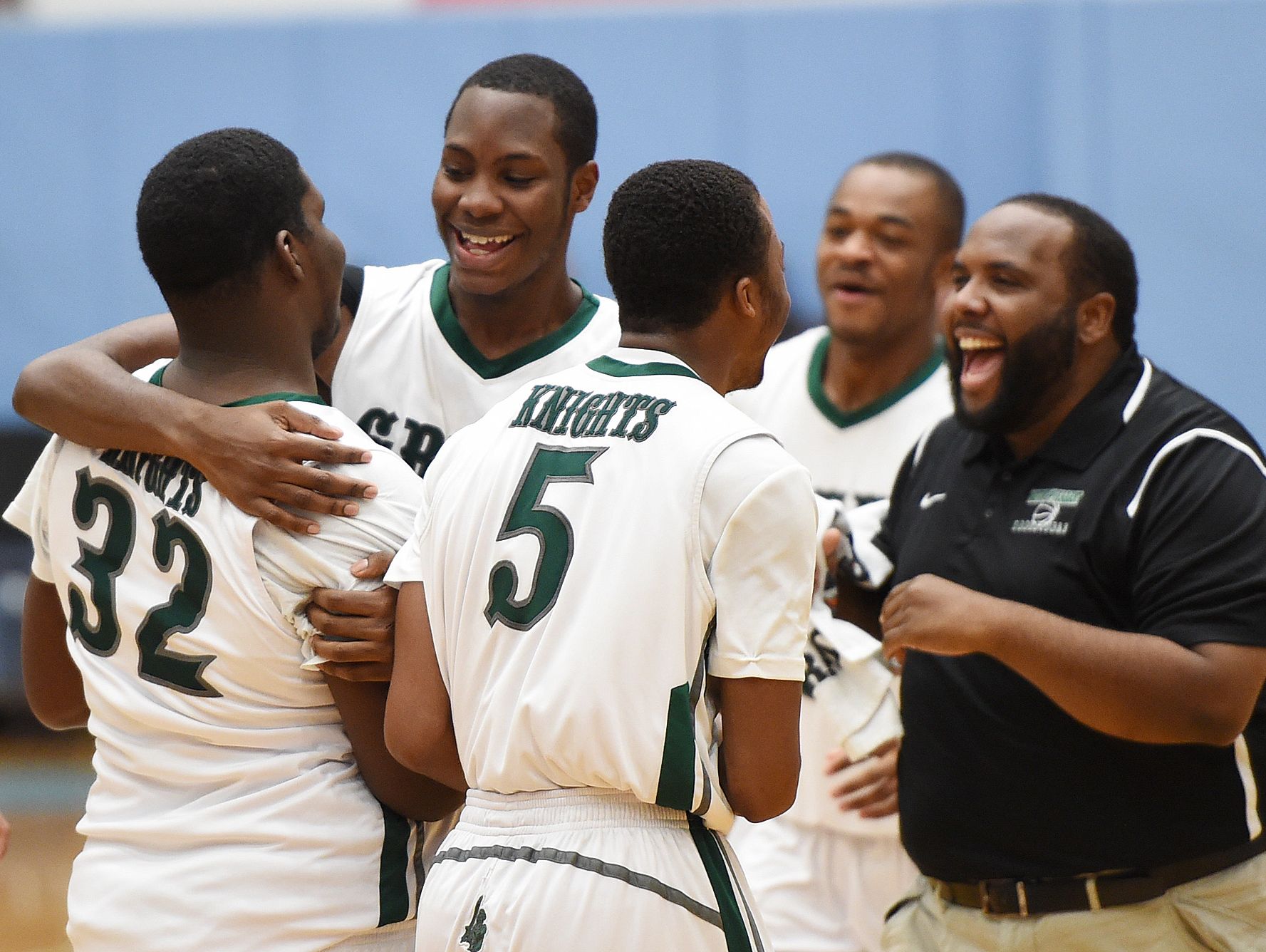 Mount Pleasant's Isaiah McCready (32) is congratulated after scoring the final basket in the Green Knights' 69-43 win over St. Michael's of Toronto at Slam Dunk to the Beach on Dec. 29