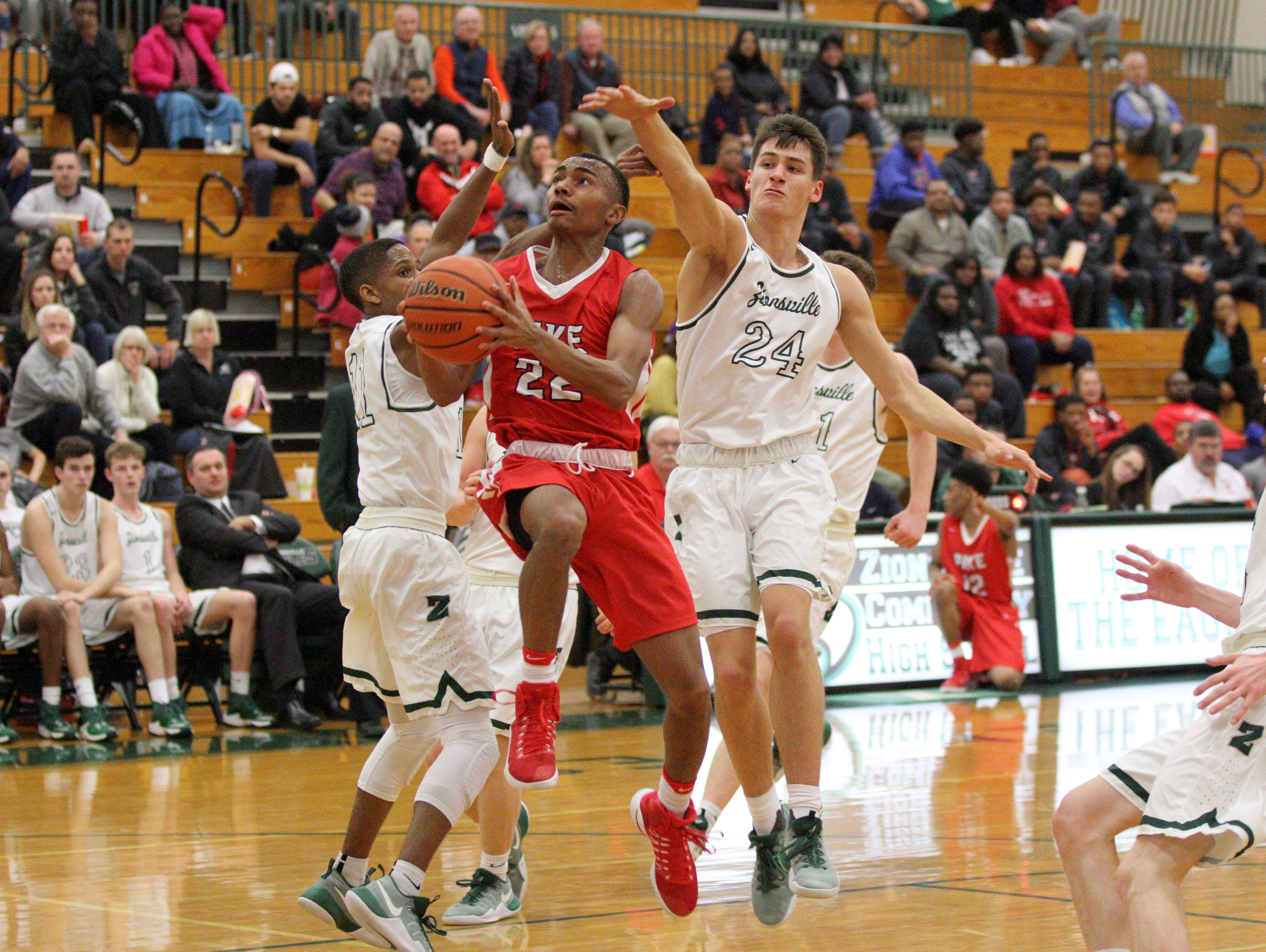 Pike's Elijah Pennington works against Zionsville's defense. Nathan Childress goes for the block.