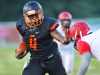 Cocoa High's QB Bruce Judson stiff arms a Lake Highland Prep defender as he turns the corner during a game held at Cocoa Stadium.