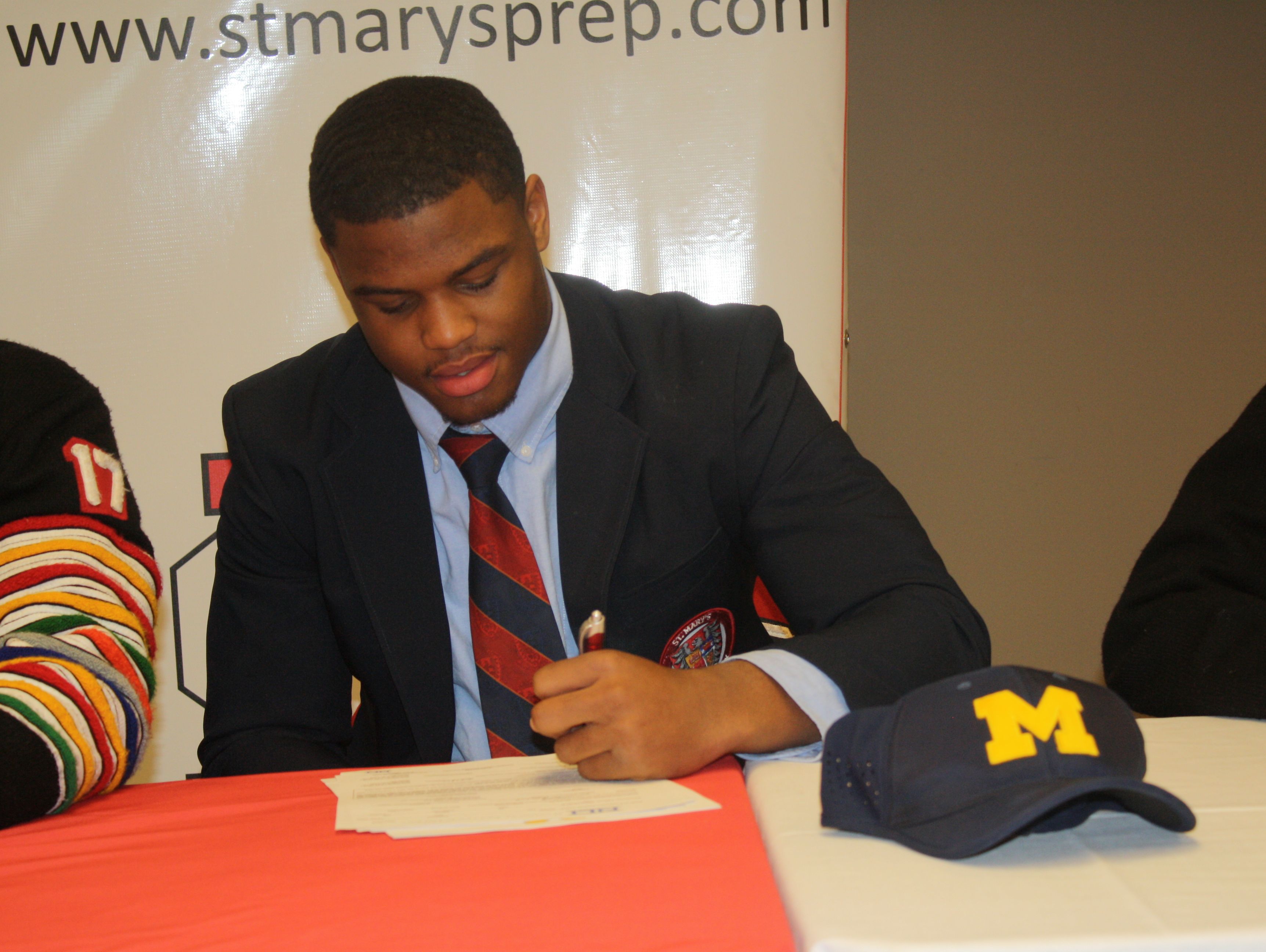 Orchard Lake St. Mary's linebacker Josh Ross signs on the dotted line to officially become a Michigan Wolverine on Wednesday after verbally committing in March 2016.