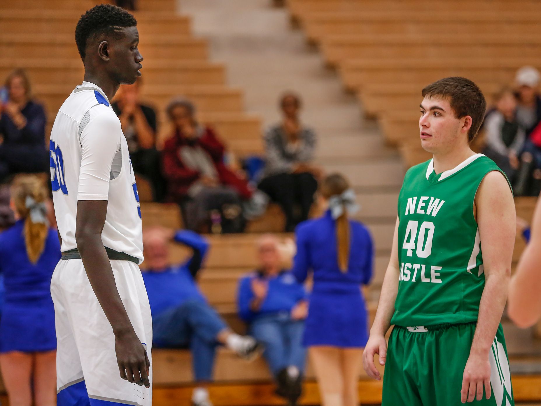 New Castle Trojans forward Bryce Webb (40) reacts after seeing Hamilton Southeastern Royals center Mabor Majak (50) just before tip-off in their junior varsity game on Tuesday, Feb. 7, 2017. Majak, who is 7 feet 1 inch tall, won the tip.
