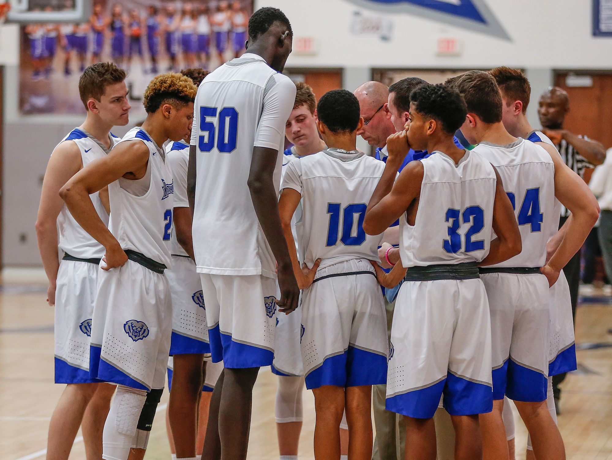 Hamilton Southeastern Royals center Mabor Majak (50) towers over his junior varsity teammates in a huddle just before tip-off against the New Castle Trojans on Tuesday, Feb. 7, 2017. Majak is freshman and stands 7 feet 1 inch tall.
