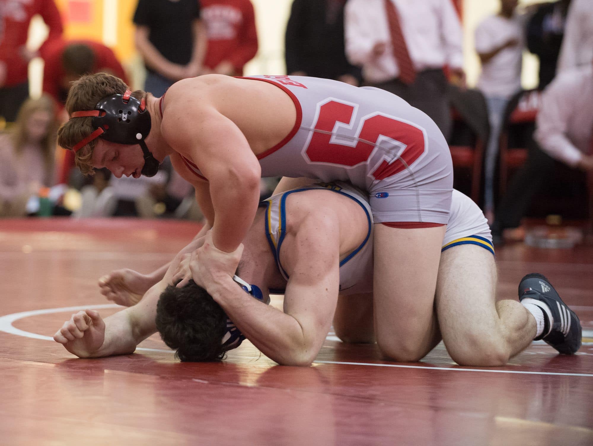 Smyrna's Larsen Wilson holds down Sussex Central's Lucas Hudson on the mat in the 182 pound match at DIAA Dual Meet Wrestling State Championship at Smyrna High School.