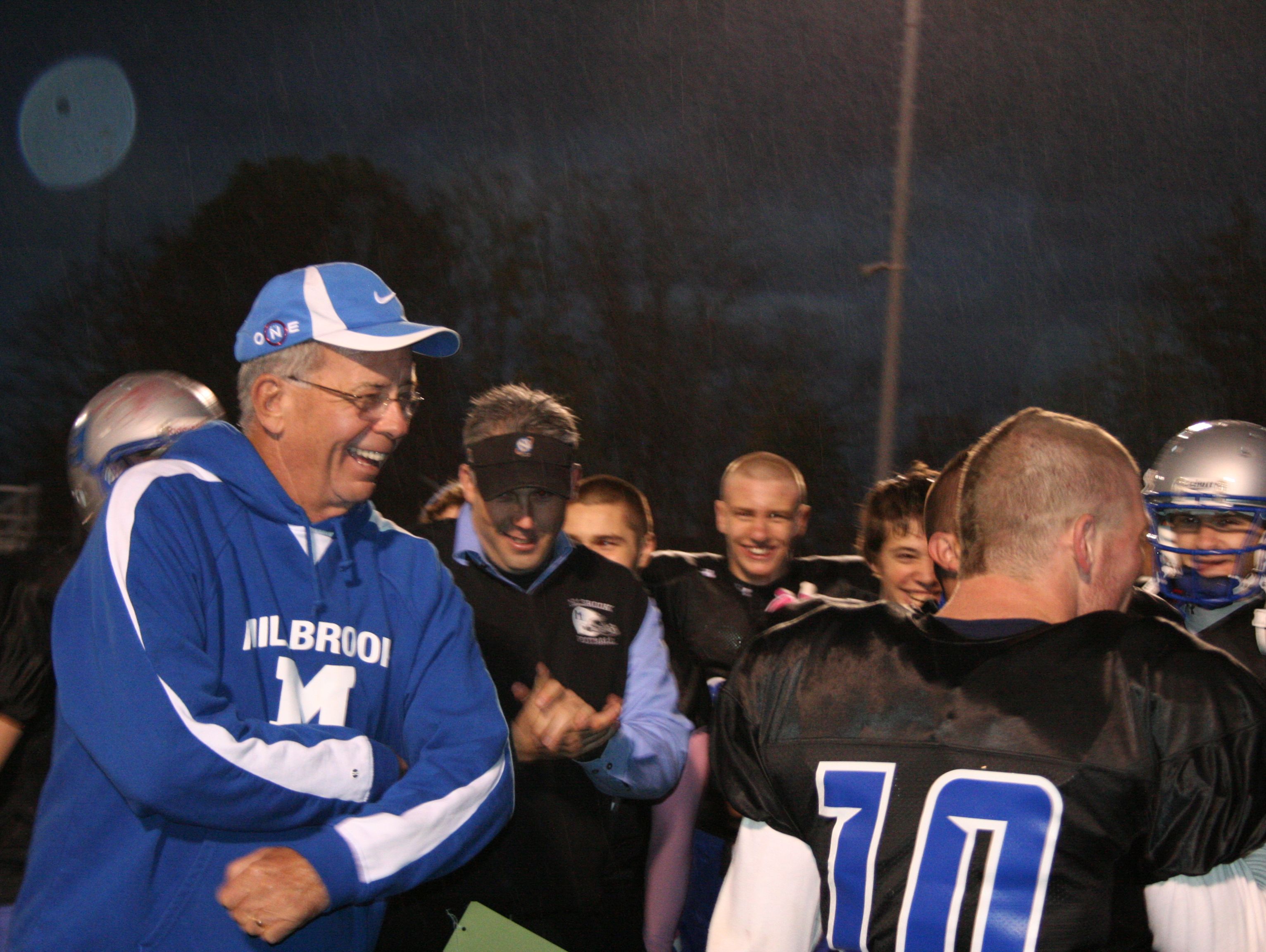 Peter Keenan, left, stands with members of the Millbrook High School football team.