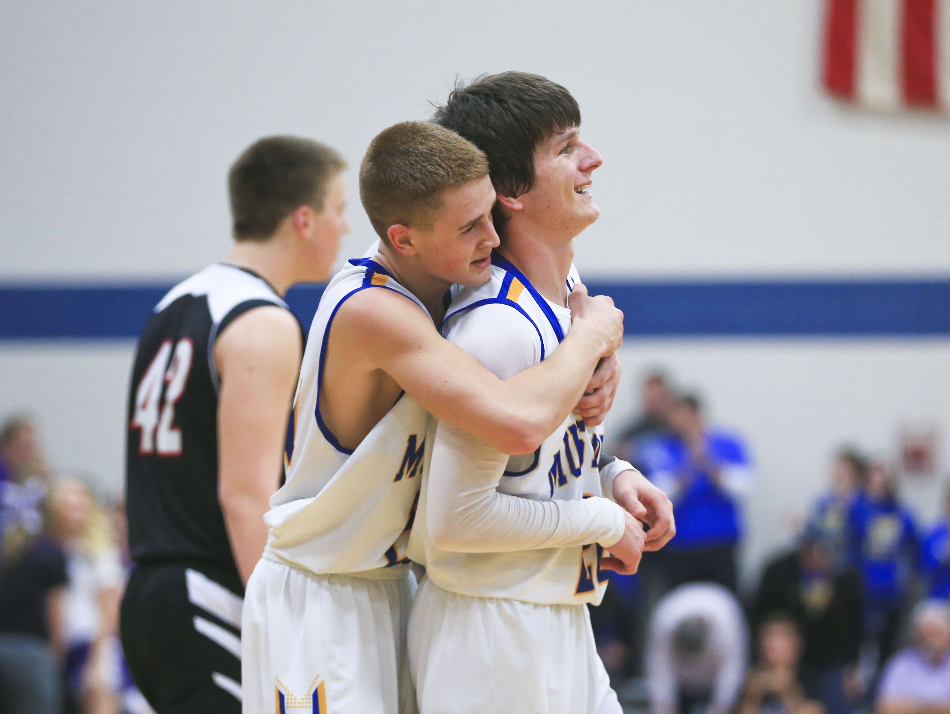 New Washington's Hunter Lind, left, congratulates teammate Brandon Horton for his late three-point score to help send the game into overtime at the Class A Semifinal Sectional at New Washington High School last season.