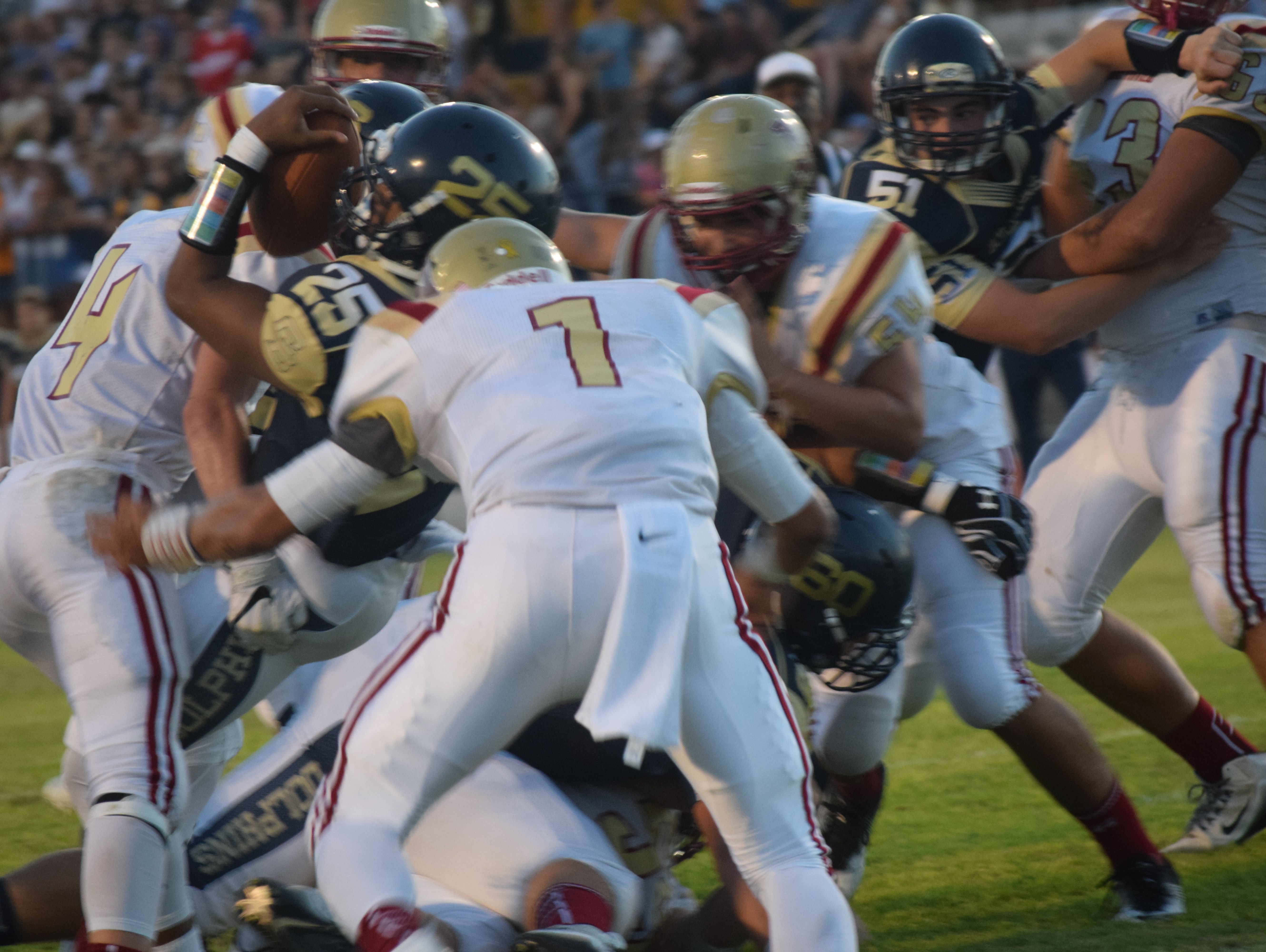 Gulf Breeze sophomore running back Carl Taylor (25) puts the ball over the plane of goal line to score the Dolphins first touchdown Friday night as Northview's Luke Ward closes in.