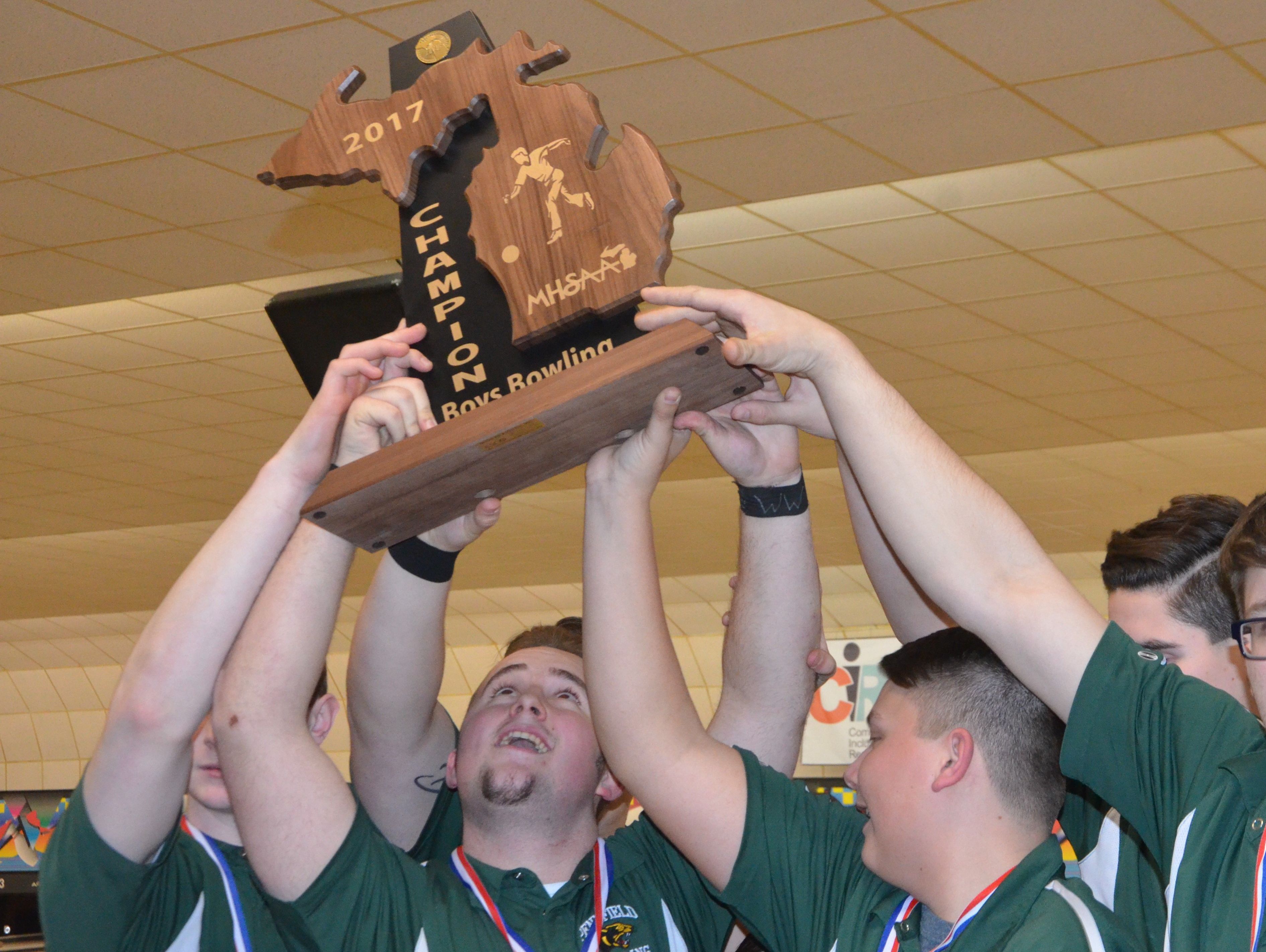Pennfield senior Max Jackson and his teammates lift up the MHSAA Division 3 Boys Bowling State Championship Trophy on Friday at M-66 Bowl in Battle Creek.