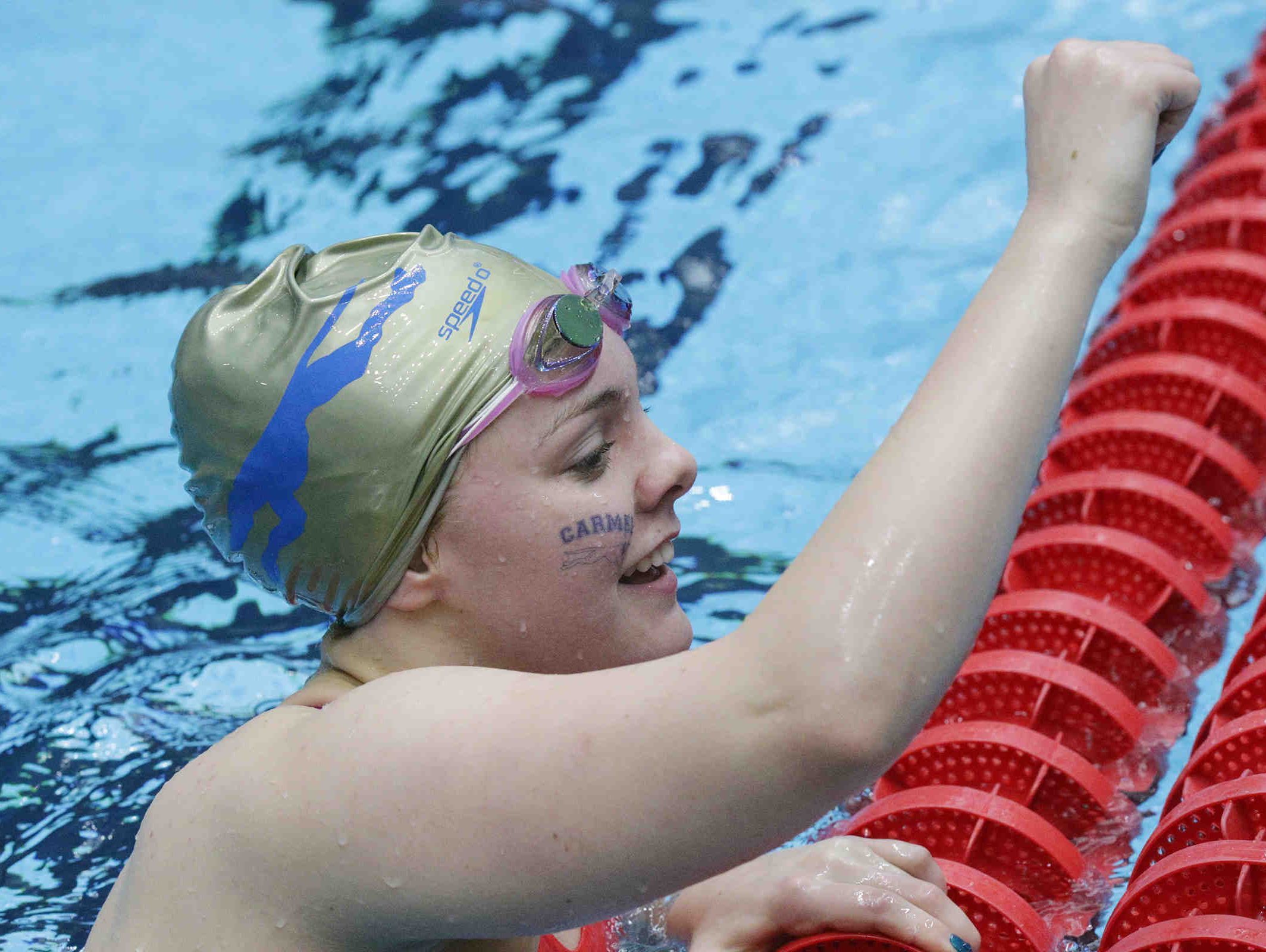 Carmel's Sammie Burchill raises her fist after competing in the girls 100 yard backstroke, during the IHSAA girls swimming state finals, held at IUPUI Natatorium, Feb. 11, 2017.