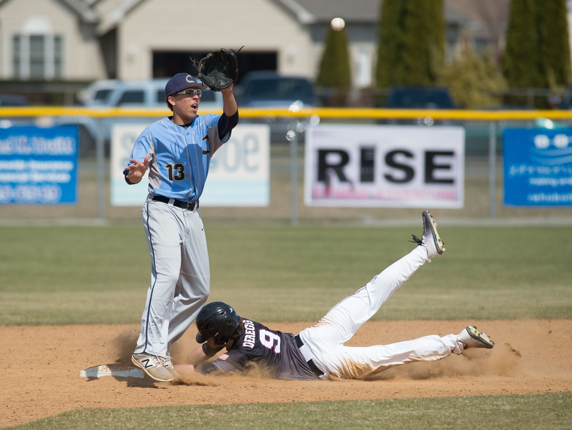 Caravel’s Ethan deRegis (9) slides into second base as the ball is thrown to Cape Henlopen’s Dwayne Harmon (13).