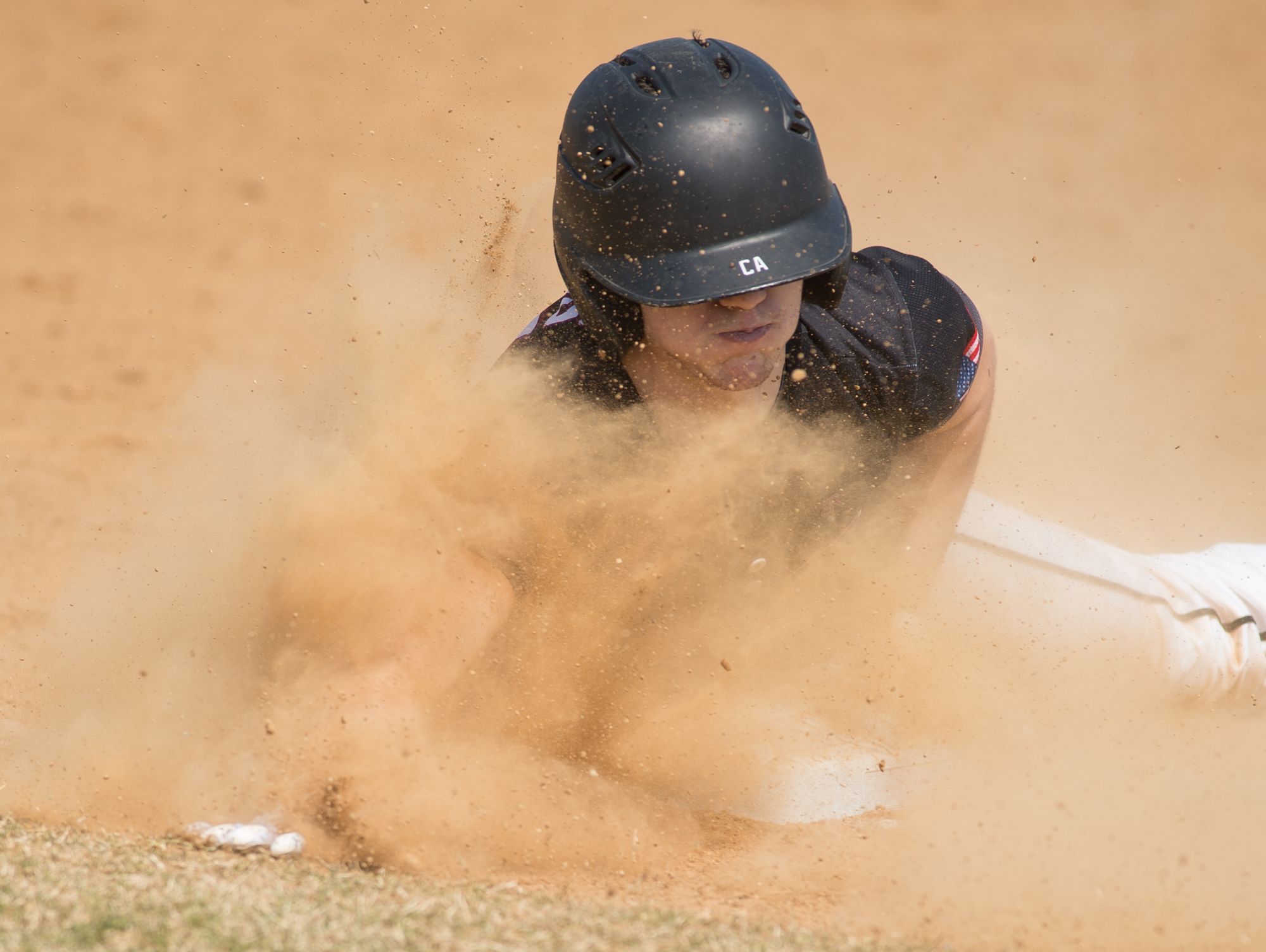Caravel’s Nick Jones (11) slides into third base after hitting a triple in their 11-10 win over Cape Henlopen.