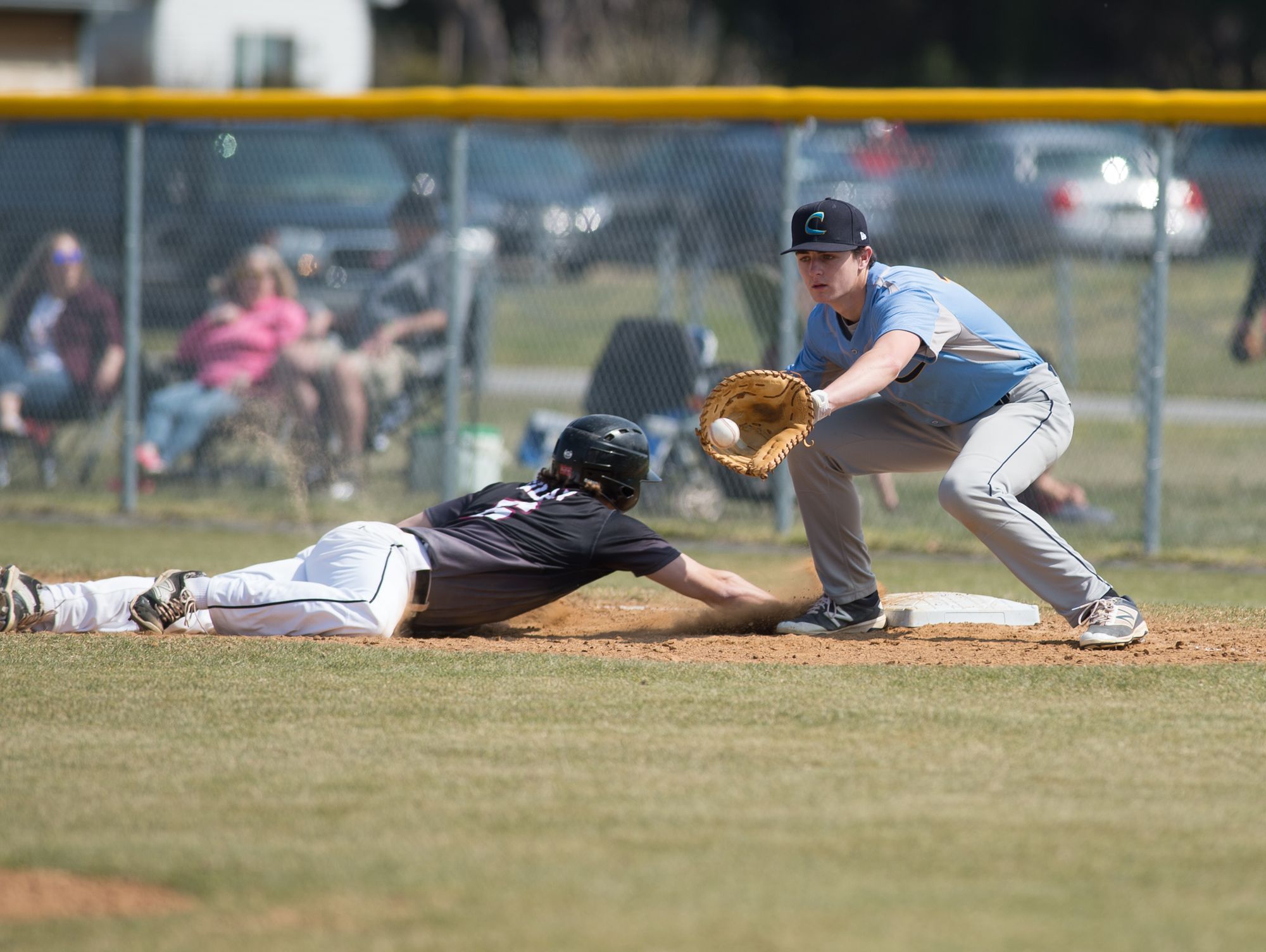 Cape Henlopen’s Connor Thompson (12) tries to tag out Caravel’s Joey Silan (6) at first base in their first inning of play.