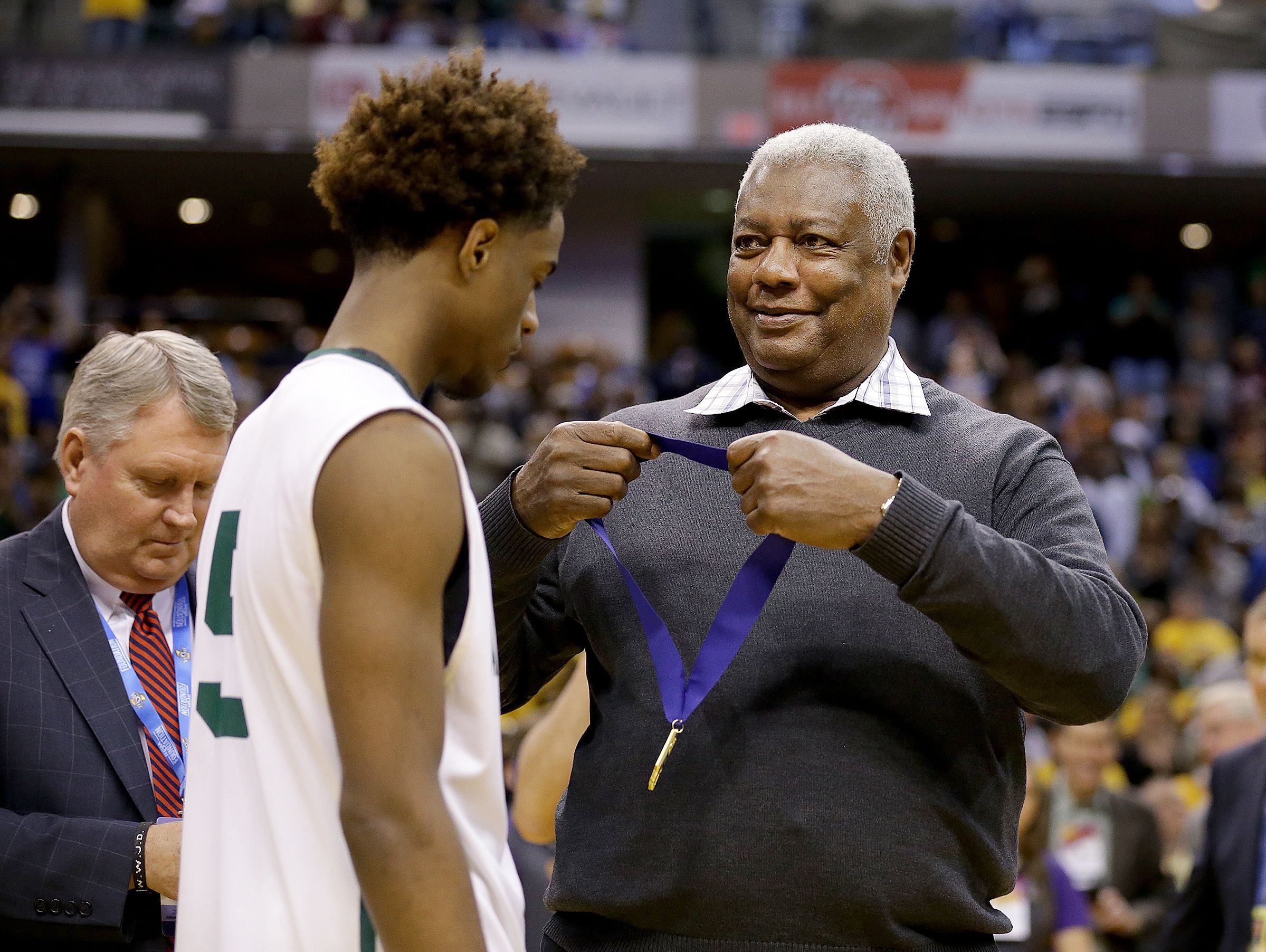 Oscar Robertson looks to put the winning medal around Crispus Attucks Tigers Jamal Harris (5) after winning the IHSAA 3A Boys Basketball State Finals game Saturday, March 25, 2017, evening at Bankers Life Fieldhouse. The Crispus Attucks Tigers defeated the Twin Lakes Indians 73-71.