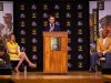 Cabool High School senior Logan Miller (center) addresses the student body during an assembly in his honor featuring Pro Football Hall-of-Famer Aeneas Williams (right)