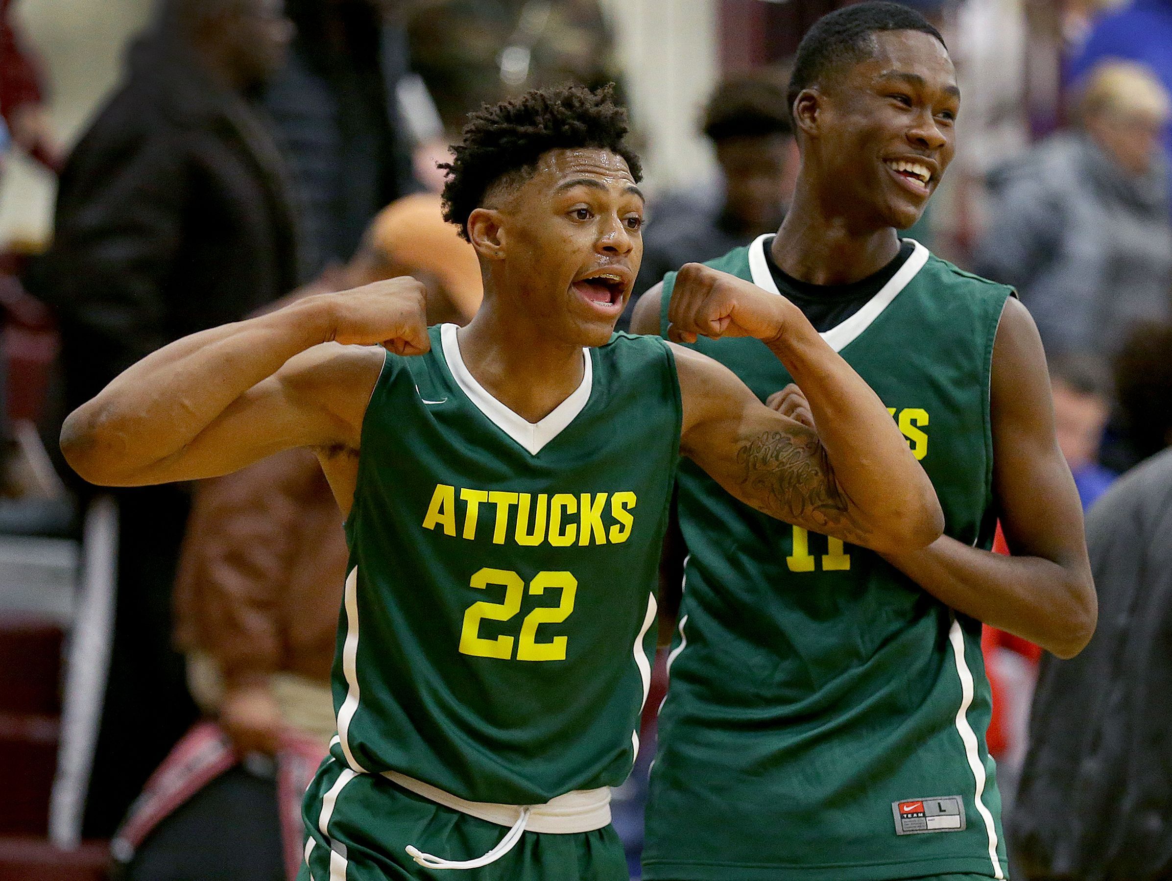 Crispus Attucks Tigers Nike Sibande (22) and Derrick Briscoe (11) begin to celebrate their win in their IHSAA 3A Sectional basketball game Friday, March 3, 2017, evening at Brebeuf Jesuit Preparatory School. The Crispus Attucks Tigers defeated the Manual Redskins 65-53.