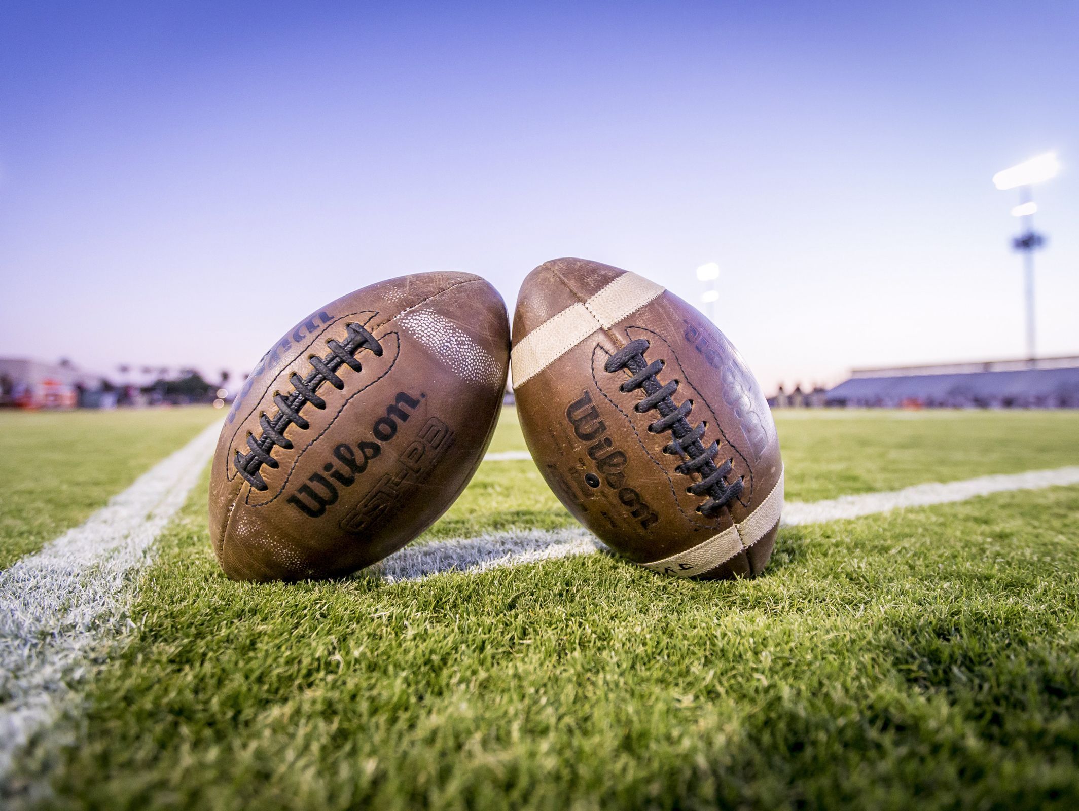 Footballs sit on an open field prior to the high school football game between Perry and Hamilton at Hamilton high school on Oct. 21, 2016 in Chandler, Ariz.
