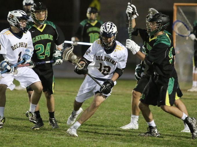 Gulf Breeze's Nick Daly, No. 12, gains possession of the ball and makes his way through the Catholic defenders earlier this season at Gulf Breeze.